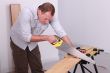 Man sawing a wooden floor