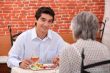 young man having lunch with his grandmother