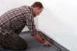 Tradesman laying down linoleum flooring