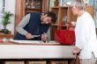 young man fixing faucet older woman