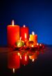 A lot of burning colorful candles against black background