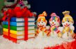 Stack of colorful books tied up with red ribbon and three snowme