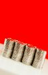 Coins stacked in bars against red background