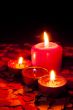 Four burning candles over red background