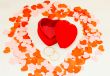 Two rings in front of a red heart shaped box