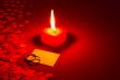 Two rings and a blank card with burning candle