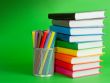 Stack of colorful books and socket with felt pens