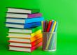 Stacks of colorful books and socket with felt pens