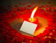 Burning heart shaped candle and a card