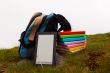 Stack of colorful books and electronic book reader