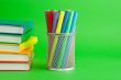 Stacks of colorful books and socket with felt pens
