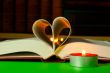 Open book with burning candle