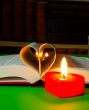 Open book with burning candle