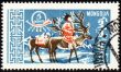 Man with reindeer in winter time on post stamp