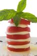 Tower of mozzarella and tomato salad with basil leaf, isolated o
