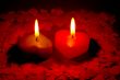 Two burning heart shaped candles
