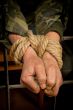 Man with hands tied up with rope