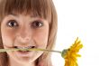 Portrait of the girl with yellow gerbera in teeth