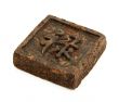 Pressed briquette of green tea with hieroglyphic on white backgr