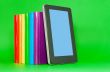 Row of colorful books and tablet PC