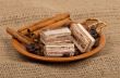 Sweets, cinnamon, nuts and coffee beans on a saucer.