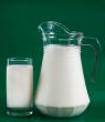 A pitcher of milk and a glass