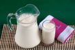 A pitcher of milk and a glass