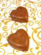 Mouthwatering chocolates in a heart-shaped on a colored background 