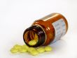 Yellow pills spill out of the bottle 