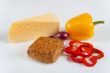 The concept of healthy food - bread with bran, vegetables and cheese on a light background