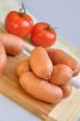 Delicious sausages on a cutting board and ripe tomatoes 