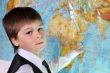 The boy is studying the physical map of the world