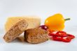 The concept of healthy food - bread with bran, vegetables and cheese on a light background