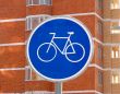 The sign of a cycle track on the background of a brick high-rises 