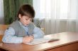 Schoolboy at his desk in the classroom makes the lessons