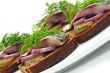 Sandwiches of rye bread with herring, onions and herbs.
