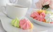 Meringue cookies on a plate with a cup of coffee