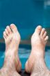 men`s feet on the background of the pool