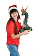Girl in Santa hat with a decorative wooden dragon