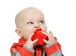 little boy chewing on a plastic pyramid in the studio