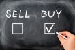 Buy or sell check boxes written on a blackboard