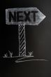 Signpost of next drawn in chalk on a blackboard