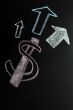 US Dollar symbol with up arrows written on a blackboard