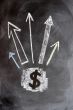 US Dollar symbol with up arrows written on blackboard