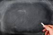 Blackboard background with a hand hold chalk