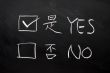 Yes and no check boxes written on a blackboard