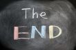 The end - handwritten with chalk on a blackboard with eraser smudges 