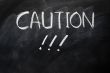 Caution written on blackboard