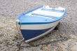 Blue and white boat on the shingle beach
