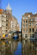 Blue boat on channel in Amsterdam. Typical Amsterdam architectur